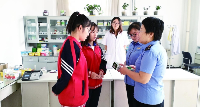 圖為執(zhí)法人員向?qū)W生普及安全用藥知識(shí)。