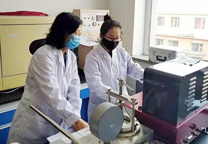 圖為吉林省器械所檢驗人員進行醫用一次性口罩的項目檢驗。