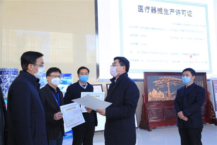 圖為甘肅省藥監(jiān)局副局長王宗偉（右二）為三家企業(yè)發(fā)放臨時《醫(yī)療器械注冊證》和《醫(yī)療器械生產許可證》 （中國食品藥品網記者丁怡媛 攝）