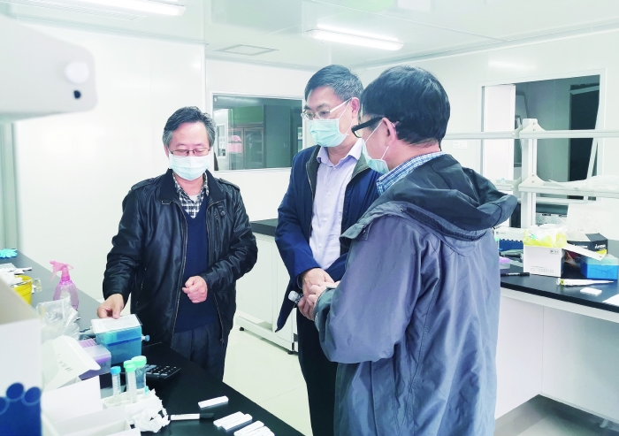2月23日，廣東省藥監局副局長嚴振（中）率隊到廣東和信健康科技有限公司幫助企業解決新冠病毒檢測試劑注冊申報問題。 王天才 攝
