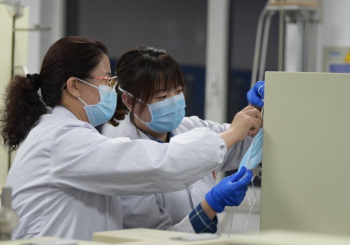 技術(shù)人員對口罩等疫情防控用品進(jìn)行檢驗(yàn)。
