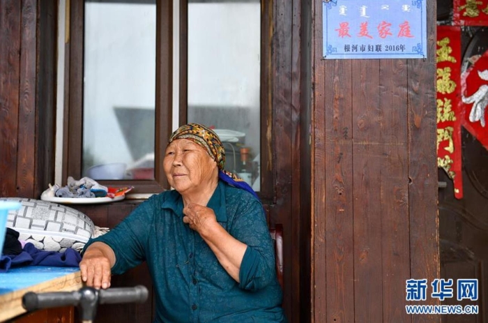 中妮浩坐在位于敖魯古雅鄂溫克族鄉(xiāng)的家門口休息（7月14日攝）。 新華社記者 貝赫 攝