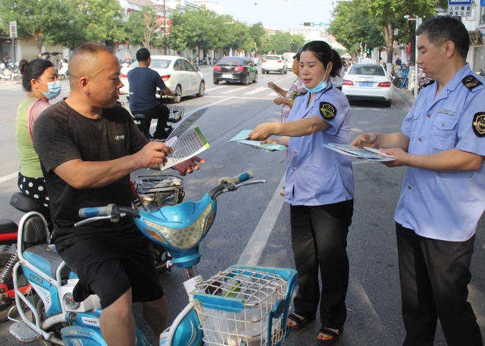 圖為該局執法人員在縣城人民路向行人發放食品安全宣傳材料。