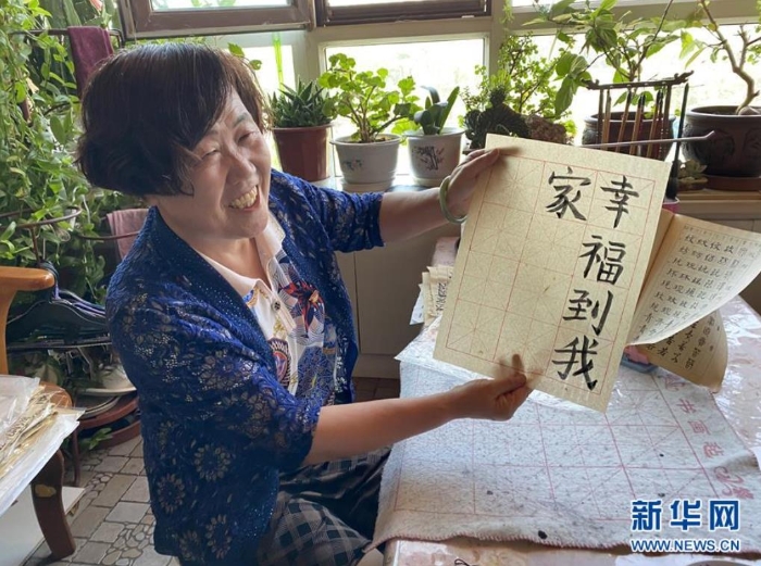 袁秀梅在自家書房寫下“幸福到我家”幾個字（8月18日攝）。 新華社記者 汪亞 攝