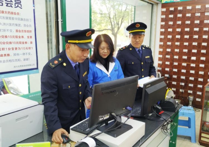 圖為執法人員在查看藥店處方藥銷售臺賬。