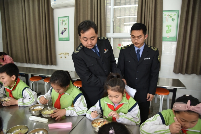 圖為執法人員檢查食堂食品安全情況。
