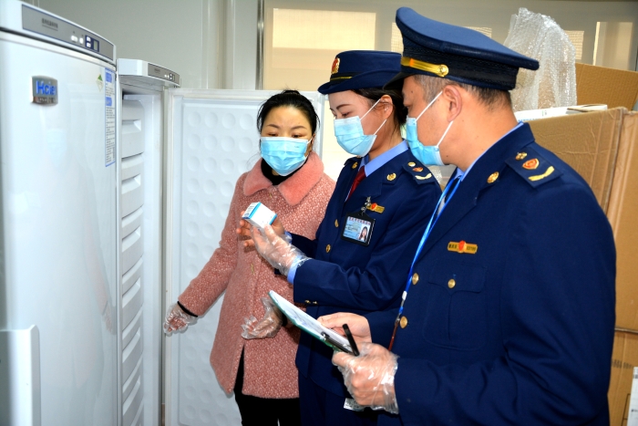 圖為執(zhí)法人員在一家醫(yī)療機構檢查新冠病毒檢測試劑儲存情況。