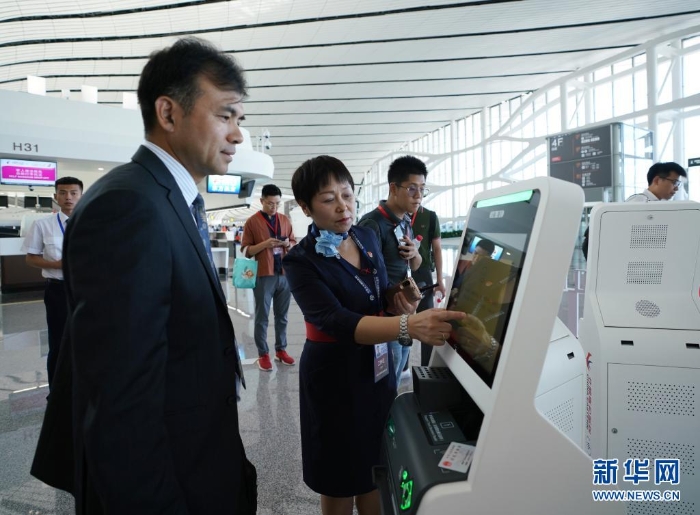中國東方航空公司工作人員（前左二）在指導乘客通過“人臉識別”辦理值機手續（2019年9月25日攝）。新華社記者 鞠煥宗 攝