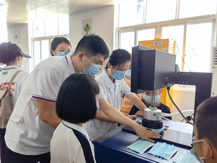 圖為技術(shù)人員在講解口罩的檢驗方法和原理。（喻燦華 攝）