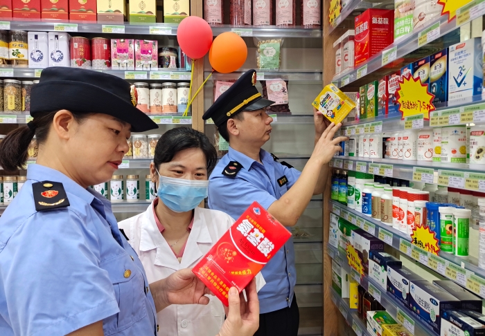 圖為7月26日執(zhí)法人員檢查保健食品標簽標識。