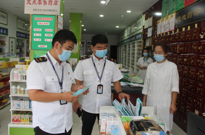 圖為執法人員在一家藥店檢查口罩產品質量。