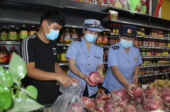 圖為執法人員和檢測機構工作人員抽取蔬菜樣品送檢。