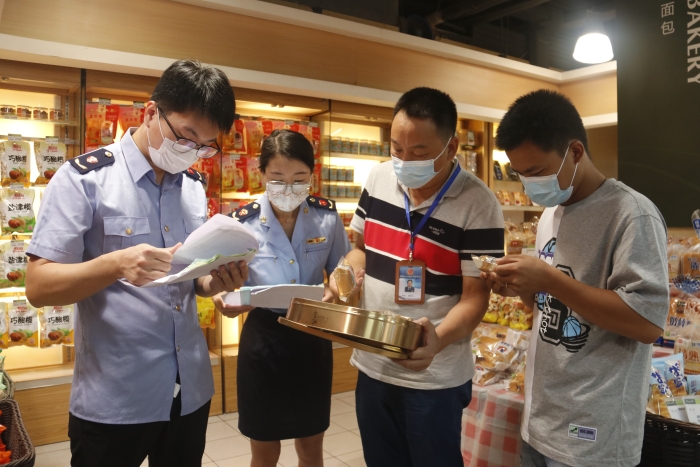 圖為執法人員查看月餅質量情況。（柯潔 攝）