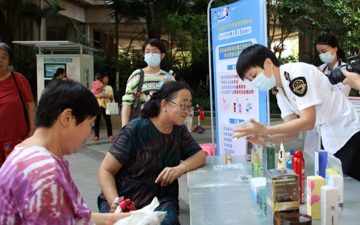 圖為檢驗人員在為群眾現場講解辨別假冒偽劣化妝品的方法。（程奇 攝）