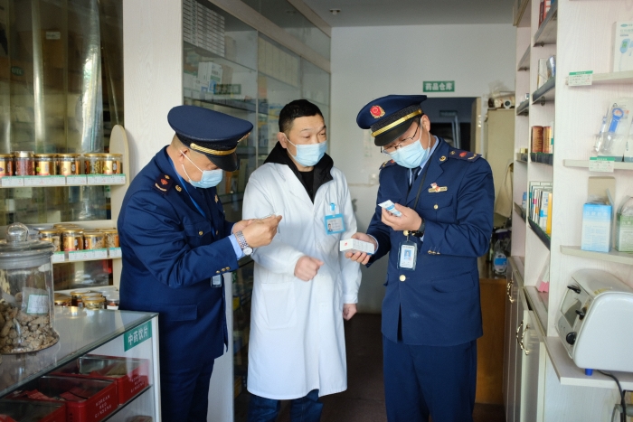 圖為執(zhí)法人員在一家藥店檢查其經(jīng)銷的藥品外包裝上標(biāo)簽是否規(guī)范，并核對(duì)相關(guān)購(gòu)銷登記臺(tái)賬的信息是否合規(guī)。