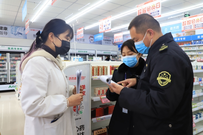 圖為1月11日?qǐng)?zhí)法人員在一家藥店檢查疫情防控情況。