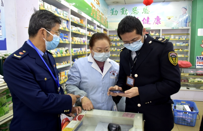 圖為執(zhí)法人員在一家藥店檢查藥品經(jīng)營(yíng)者的智慧監(jiān)管系統(tǒng)的使用情況。