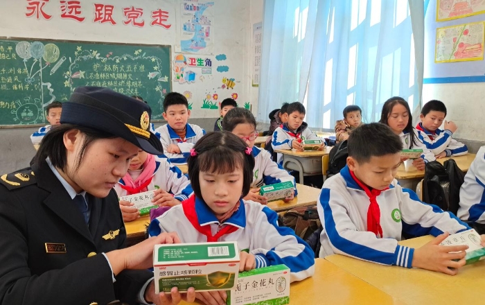 圖為工作人員在嶺背鎮中心小學向同學們講解藥品安全知識。