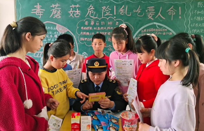 圖為該縣市場監管局嶺背分局工作人員在嶺背大窩小學向學生講解如何鑒別假冒偽劣食品藥品。王雨林 段丁長 攝