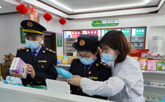 圖為執(zhí)法人員在藥店檢查疫情防控用品質(zhì)量。