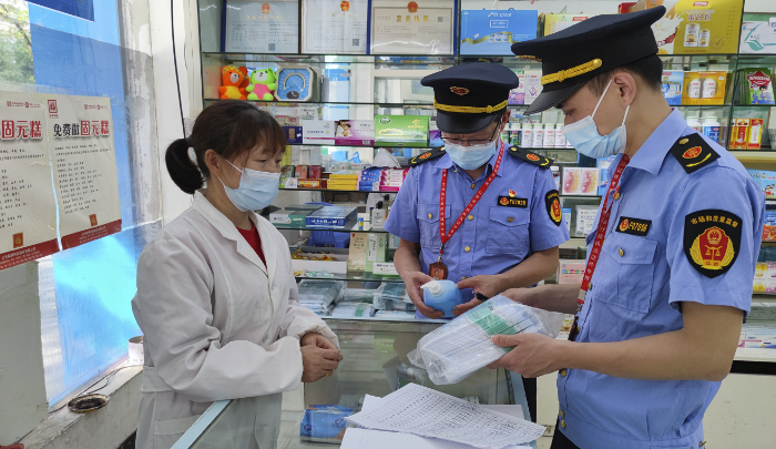圖為執法人員在藥店檢查防疫藥品價格。