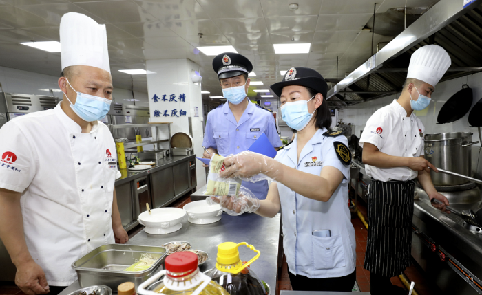 圖為淮北市市場監管局執法人員在一家學校食堂檢查食品加工環境。