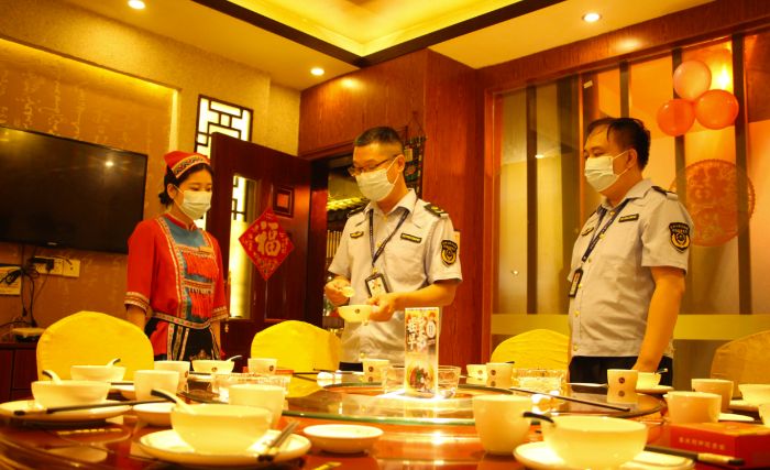 圖為鐘山縣市場監管局執法人員在一家飯店檢查餐飲具清洗消毒情況。