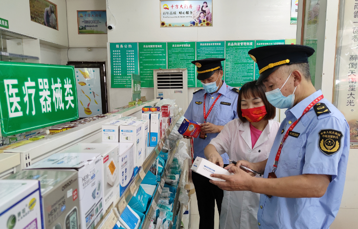 圖為南豐縣市場監管局執法人員在一家藥店檢查醫療器械是否有合格證明。