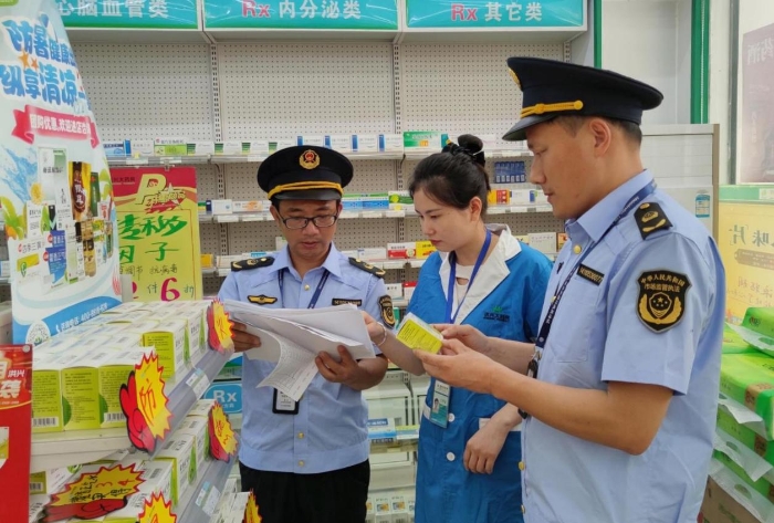 圖為6月5日?qǐng)?zhí)法人員在一家藥店檢查防暑藥品質(zhì)量情況。