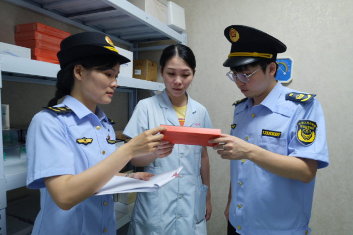 圖為該局執(zhí)法人員在醫(yī)療美容機構(gòu)檢查醫(yī)療器械產(chǎn)品，并向從業(yè)人員進行科普相關(guān)知識。