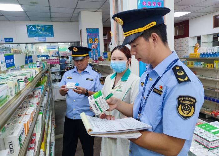 圖為執法人員在一家藥店檢查抗病毒藥品質量。