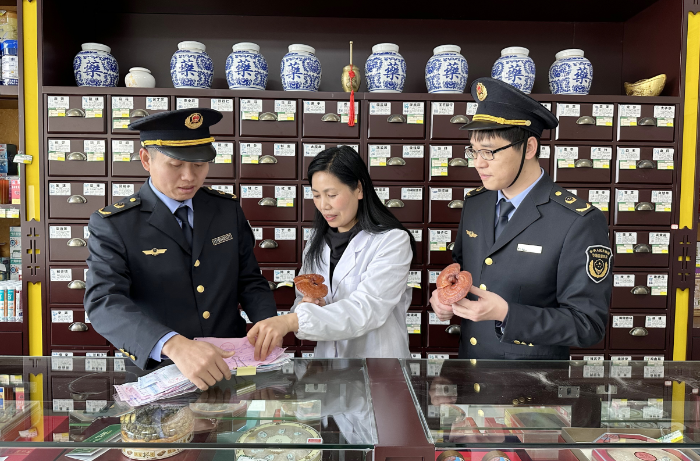 圖為該局監(jiān)管人員在一家藥品零售企業(yè)檢查滋補類中藥飲片進貨臺帳及儲存情況。