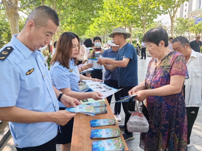 圖為工作人員向群眾發放禁毒宣傳手冊。