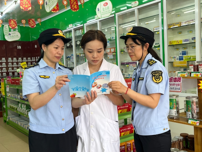 圖為8月28日，該局執(zhí)法人員會同上思縣市場監(jiān)管局在一家藥店向從業(yè)人員派發(fā)宣傳資料。（廖開軍 凌莉萍 攝）